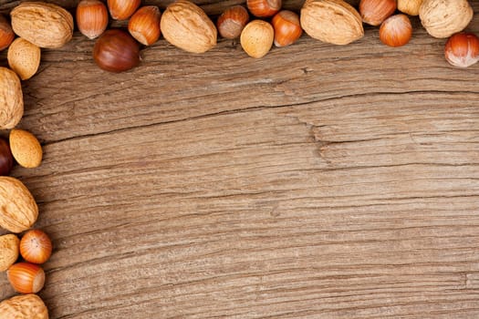 Background made of old wooden panel decorated with various nuts on two sides