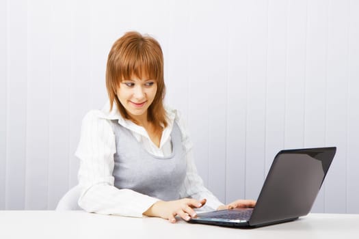 attractive young girl with surprise stares at the monitor laptop