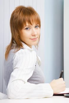 portrait of an attractive girl with a notebook in the office