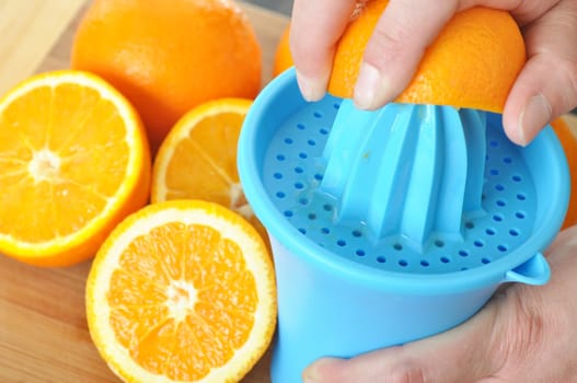 Preparing 100% orange juice using squeezer.