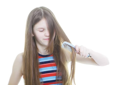Dissatisfied with teen girl combing her long hair tangled