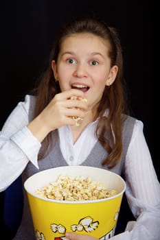 emotional girl with popcorn on a black background
