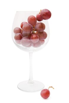 red grapes in a wine glass on a white background