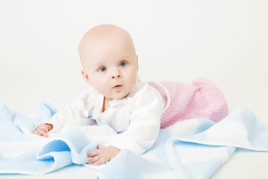 little blue-eyed girl with a blue towel. baby. Studio photography