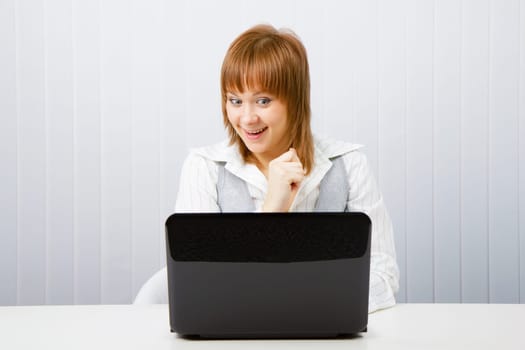 joyful surprise a girl with a laptop in the office