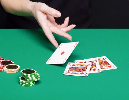 female hand with a winning card combinations. Green tables, chips, cards