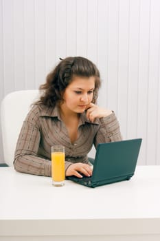 The young brunette at office with the laptop