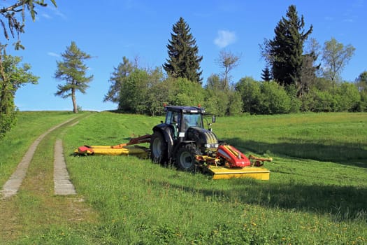 A farmer mowing with a tractor
