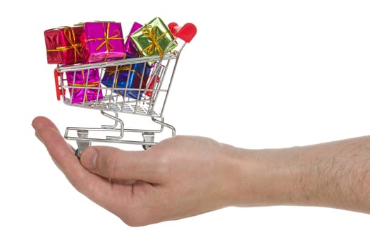 Hand with shopping cart full of gifts. Isolated on white background
