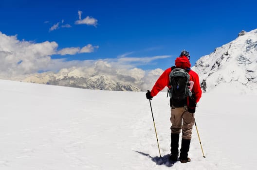 Mountain trekker looking at high winter Himalayas mountains, Nepal