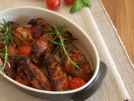 Spicy chicken wings in a creamic bowl with herbs