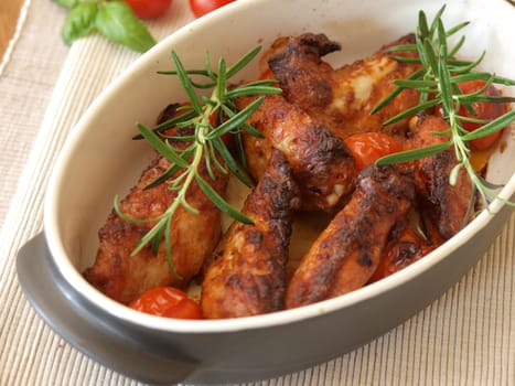 Spicy chicken wings in a creamic bowl with herbs