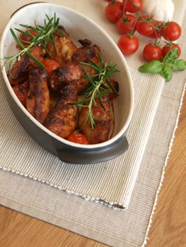 Spicy chicken wings in a creamic bowl with herbs