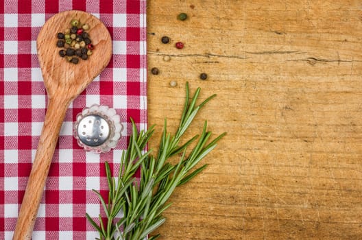 Rustic wooden background with checkered tablecloth and cooking spoon