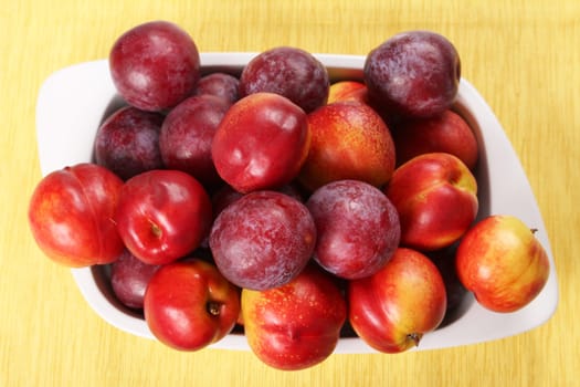 Nectarines and Plums in a ceramic dish.