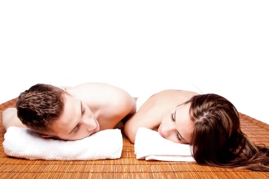 Couples holiday retreat at relaxing health spa for beauty treatment waiting for massage laying on bamboo.