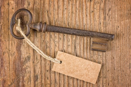 Old key with pendant on a wooden board