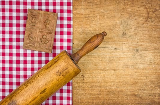 Pasta pin with wooden model on a wooden board with checkered tablecloth