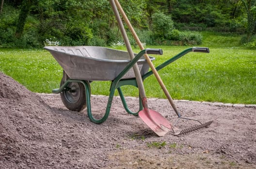 Wheelbarrow with shovel and rake