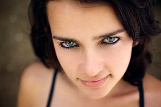 Pretty girl with green eyes, portrait of happy young hispanic woman looking at camera and smiling