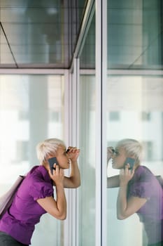 business woman in a hurry applying make up outdoor and looking at office building window