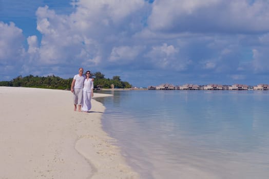 happy young couple have fun and relax at summer vacation on background maldives travel location and beautiful white sand beach
