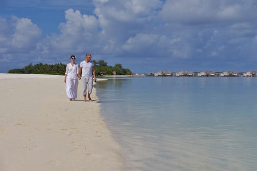 happy young couple have fun and relax at summer vacation on background maldives travel location and beautiful white sand beach