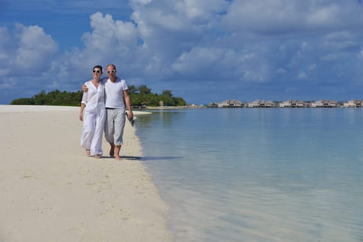 happy young couple have fun and relax at summer vacation on background maldives travel location and beautiful white sand beach