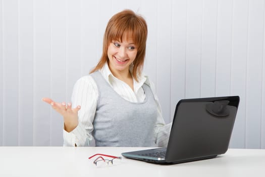 Delighted girl looks at a monitor. Office