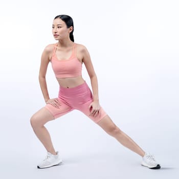 Young attractive asian woman in sportswear stretching before fitness exercise routine. Healthy body care workout with athletic woman warming up on studio shot isolated background. Vigorous