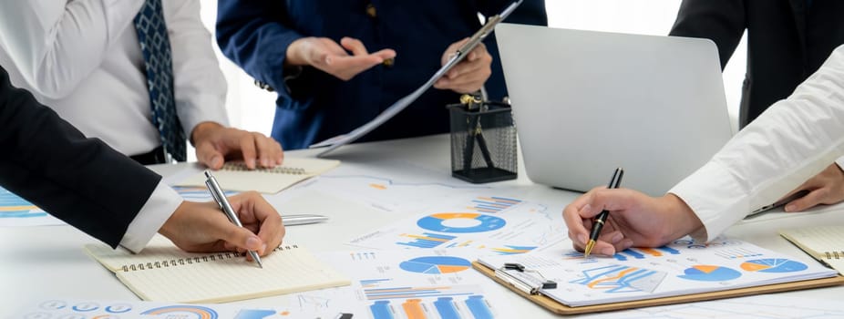 Business people in group meeting in formal attire share idea discussing report for company profit in creative workspace for start up business shot in close up view on group meeting table . Oratory .