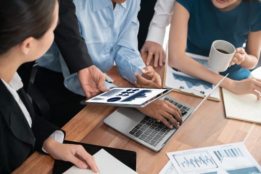 Multiracial analyst team use BI Fintech software to analyze financial data on meeting table. Financial dashboard data display on laptop screen with analyzed chart for marketing indication. Concord