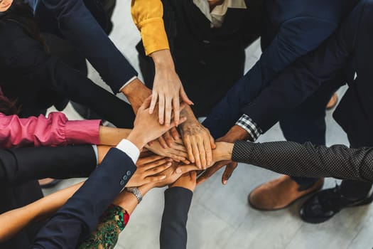 A group of diversity people putting their hands together. Showing unity teamwork and friendship. Close up top view of young business man and business woman joining as a team. Intellectual.