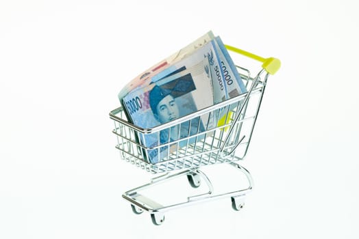 Indonesian rupiah in shopping cart over white