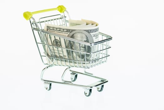 Dollars in shopping cart over white background