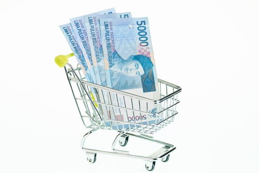 Indonesian rupiah in shopping cart over white