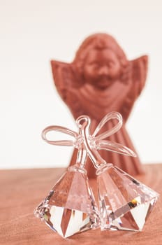 Crystal bells ornament close up with chocolate Angel at the background