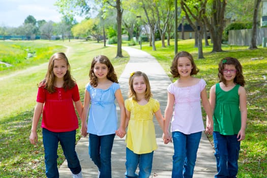 Children group of sisters girls and friends walking happy in the park outdoor