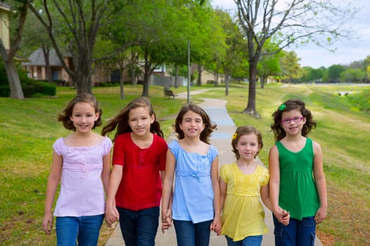 Children group of sisters girls and friends walking happy in the park outdoor