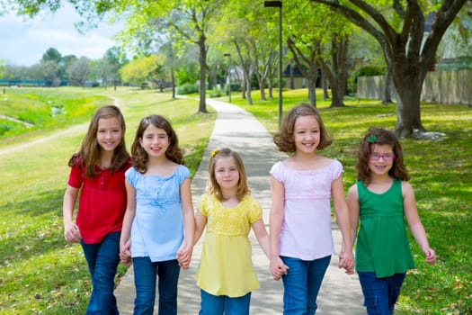 Children group of sisters girls and friends walking happy in the park outdoor