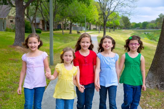 Children group of sisters girls and friends walking happy in the park outdoor