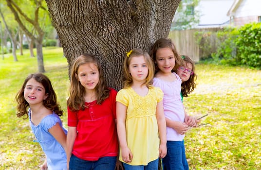 Children group friend girls friends playing on tree trunk at the park outdoor