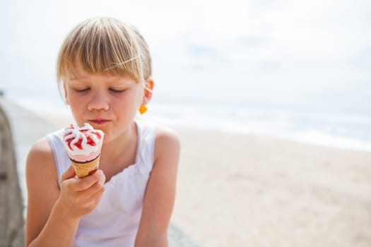 Young cute girl holding ice cream near beach