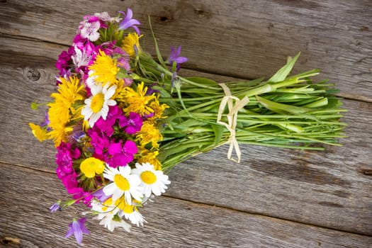 Colorful bouquet of wildflowers on the old wooden floor