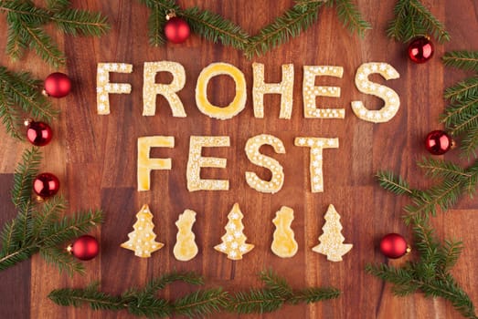 the german words frohes fest which means merry christmas with christmas decorations and cookies