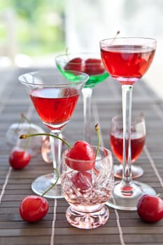 Cherry liquor in small jars with fresh cherries
