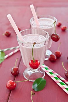 Two Glser with milkshake with fresh cherries