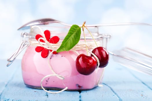 Cherry yogurt on blue wooden table