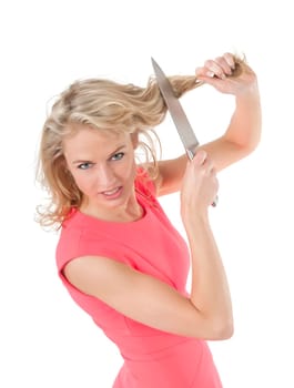 angry woman cuts her hair with a kitchen knife