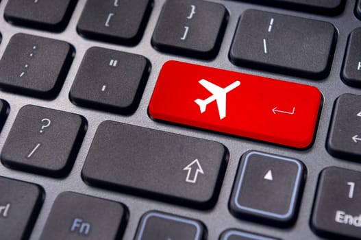 a plane sign on keyboard, to illustrate online booking or purchase of plane ticket or business travel concepts.
